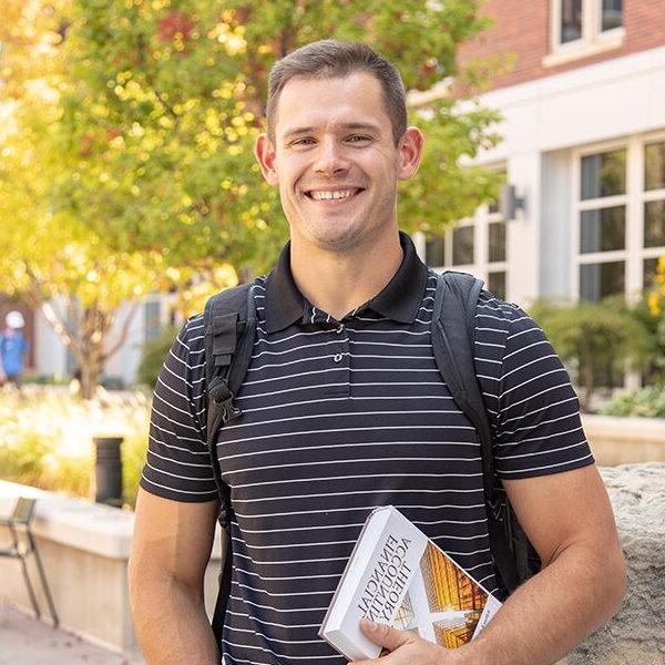 Mason Hampton stands in front of the COBE building on campus.